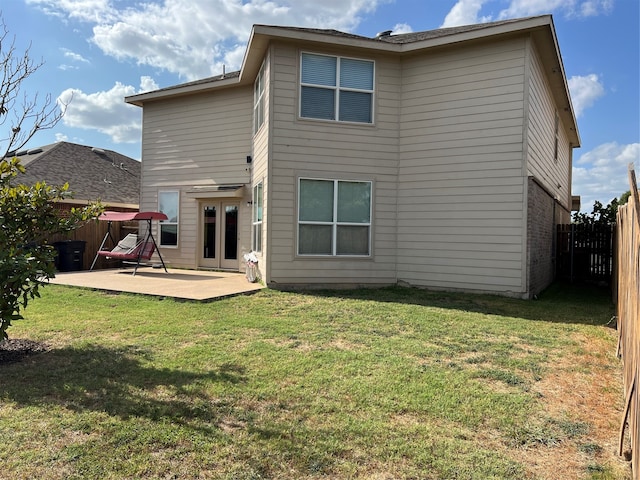 back of property with a patio area and a lawn