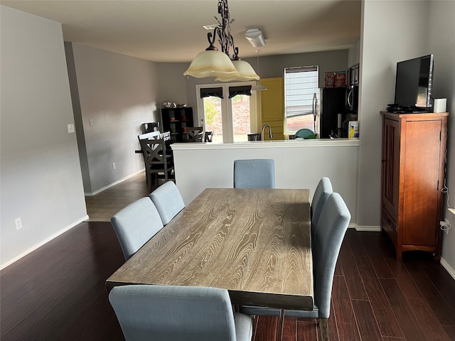 dining area featuring sink and dark wood-type flooring