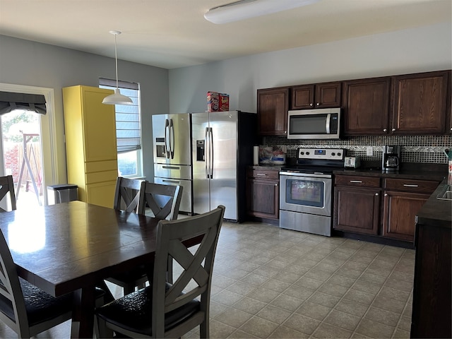 kitchen featuring decorative light fixtures, backsplash, plenty of natural light, and stainless steel appliances