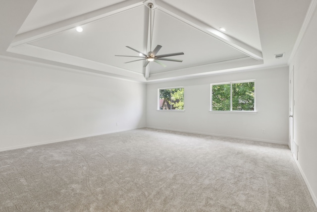 carpeted spare room featuring vaulted ceiling with beams, a tray ceiling, crown molding, and ceiling fan