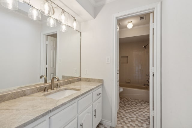 full bathroom with tile patterned flooring, toilet, vanity, tiled shower / bath combo, and ornamental molding