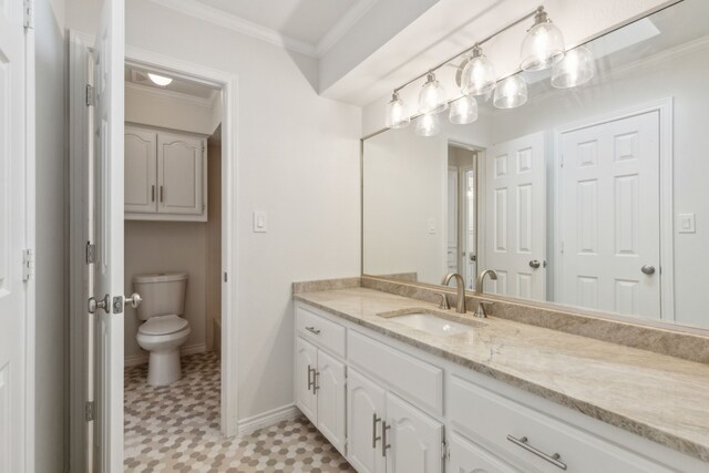 bathroom featuring vanity, toilet, tile patterned floors, and crown molding