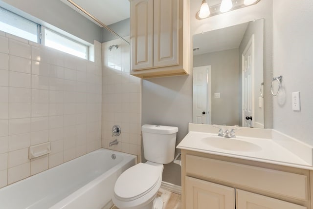 full bathroom featuring tiled shower / bath combo, vanity, and toilet