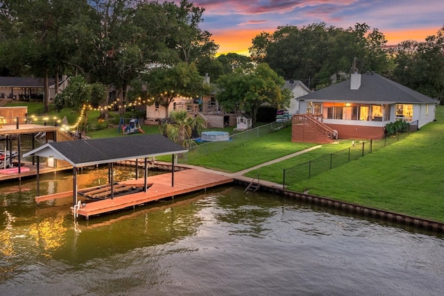 view of dock with a water view and a yard