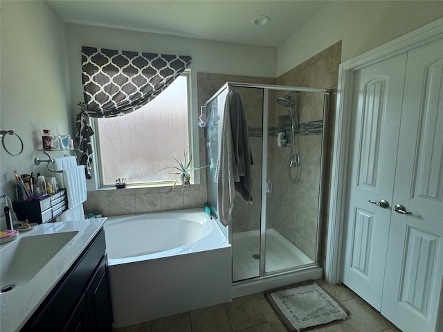 bathroom featuring tile patterned floors, vanity, and shower with separate bathtub