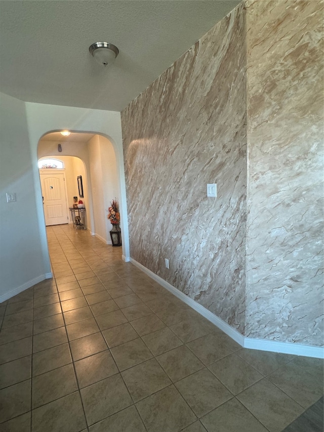 hall with dark tile patterned flooring