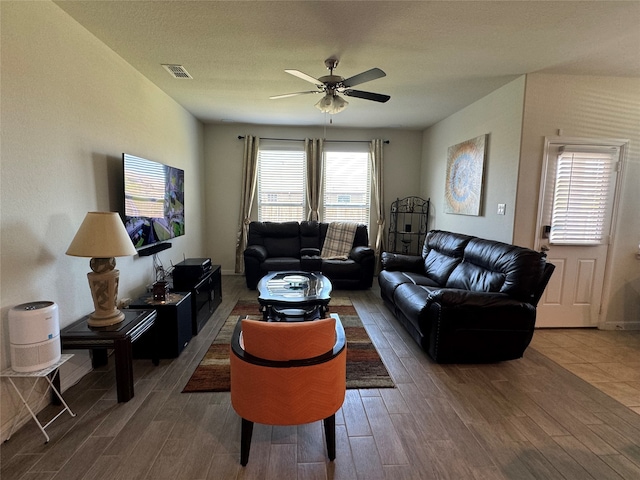 living room featuring ceiling fan, wood-type flooring, and a textured ceiling