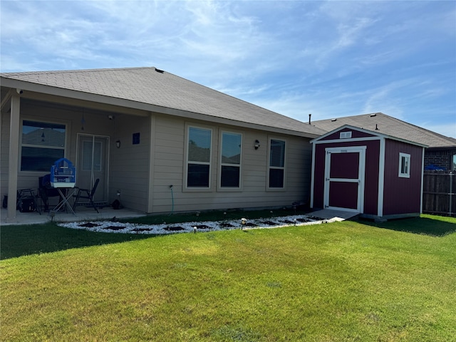 rear view of property featuring a storage unit and a yard