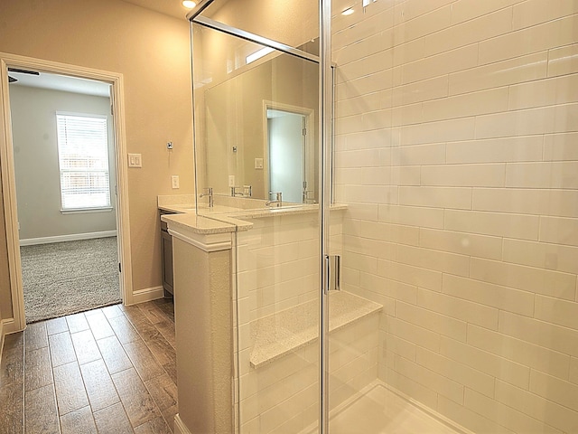 bathroom with vanity, an enclosed shower, and wood-type flooring