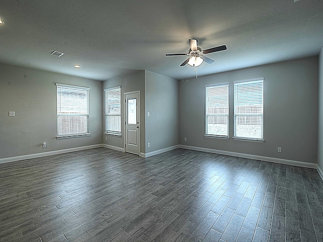 spare room featuring dark hardwood / wood-style floors, a textured ceiling, and ceiling fan