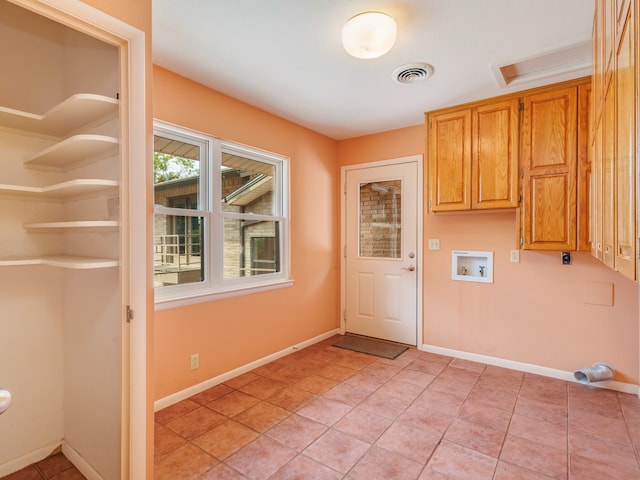 interior space with hookup for a washing machine, cabinets, and light tile patterned floors