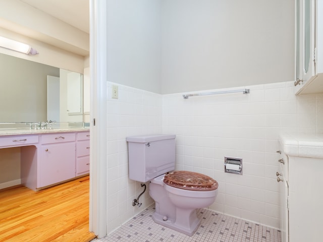 bathroom with tile patterned flooring, tile walls, toilet, and vanity