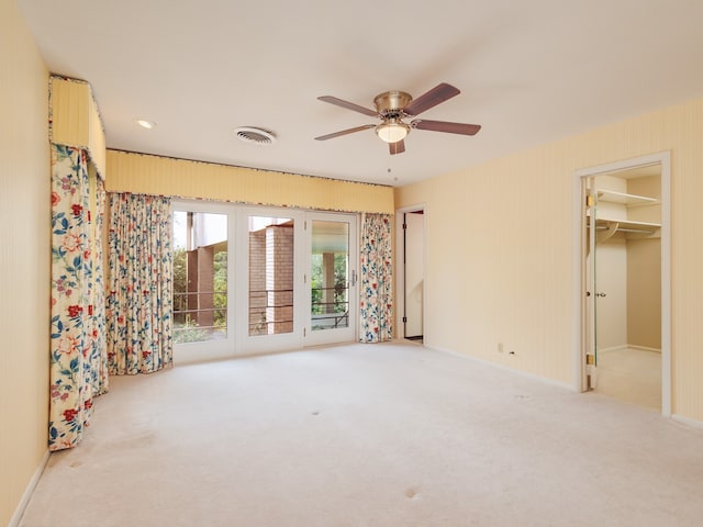 spare room featuring light colored carpet and ceiling fan