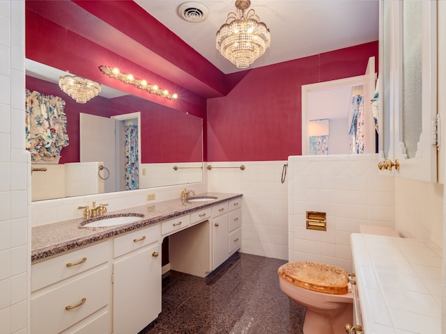 bathroom with vanity, tile walls, an inviting chandelier, toilet, and tile patterned flooring