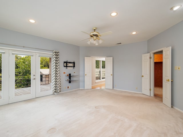 unfurnished living room with a wealth of natural light, light colored carpet, french doors, and ceiling fan