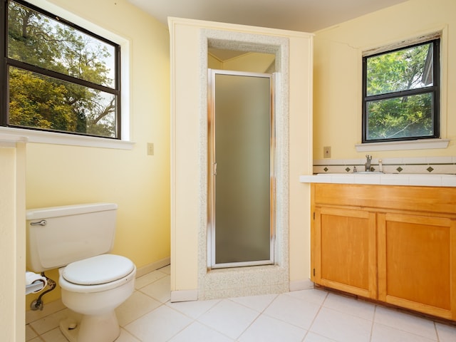 bathroom featuring a healthy amount of sunlight, tile patterned floors, toilet, and vanity