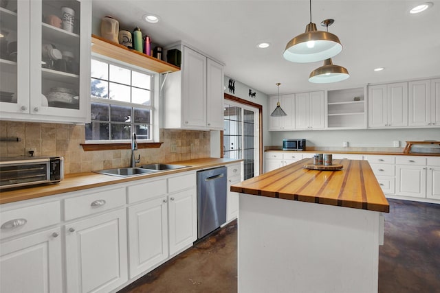 kitchen featuring a kitchen island, decorative light fixtures, white cabinetry, butcher block counters, and stainless steel dishwasher