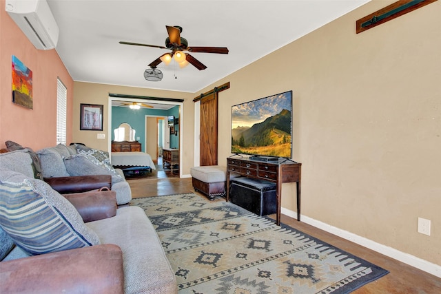 living room with ceiling fan, a barn door, and an AC wall unit