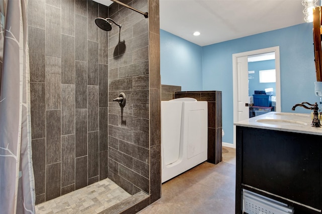 bathroom with vanity, washer / dryer, concrete flooring, and walk in shower