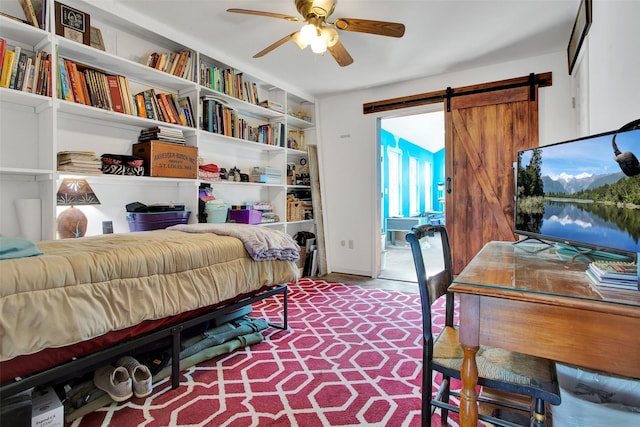 bedroom featuring a barn door and ceiling fan