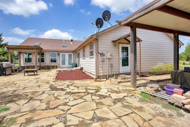 rear view of property featuring a patio and a pergola