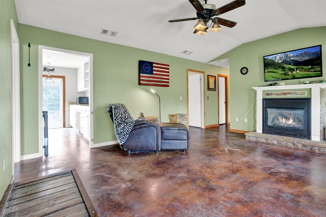 living room featuring ceiling fan, lofted ceiling, and a stone fireplace