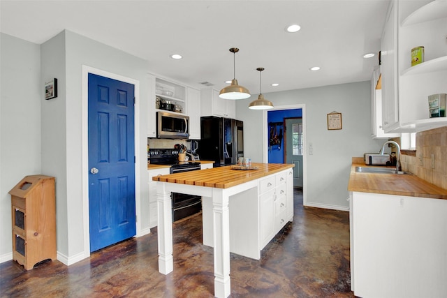 kitchen with wood counters, sink, a center island, hanging light fixtures, and black appliances