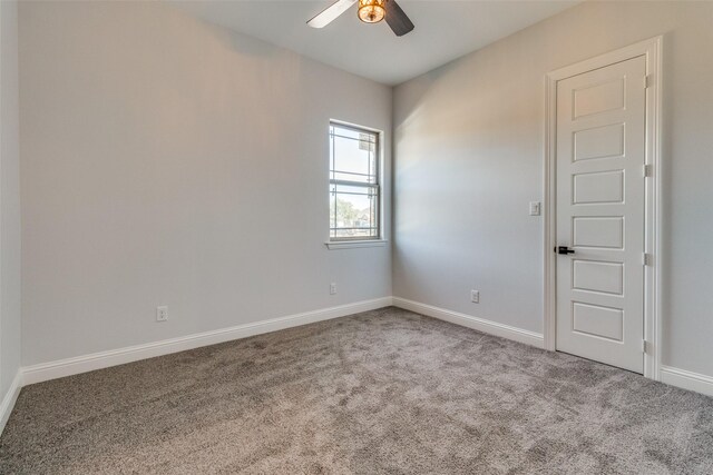 spare room with ceiling fan and light carpet