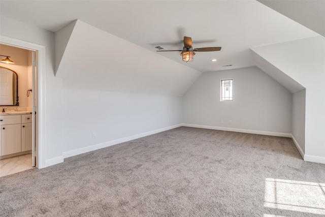 additional living space featuring vaulted ceiling, light colored carpet, and ceiling fan