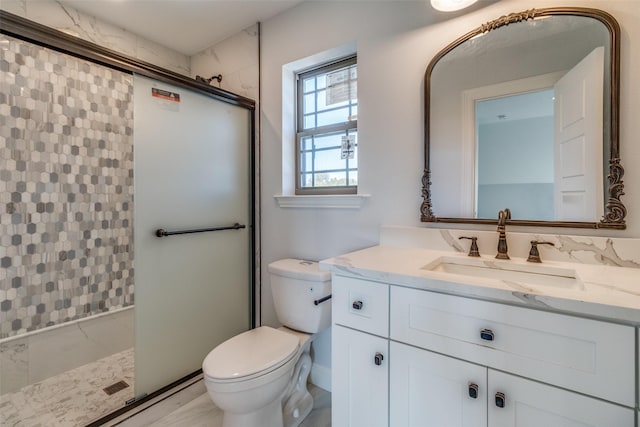 bathroom featuring vanity, toilet, and a shower with shower door