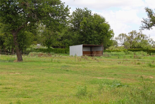 view of yard featuring a rural view and an outbuilding