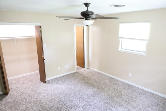 unfurnished bedroom featuring light carpet, ceiling fan, and a closet