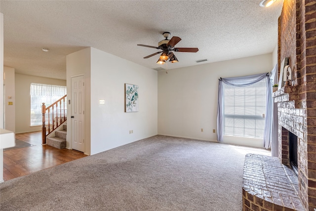 unfurnished living room with hardwood / wood-style floors, a textured ceiling, plenty of natural light, and ceiling fan