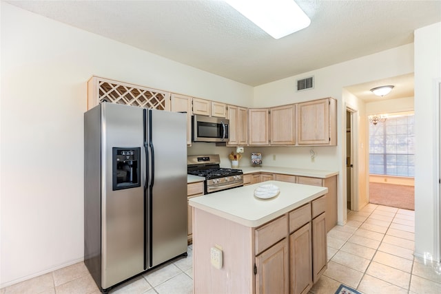 kitchen featuring a notable chandelier, a textured ceiling, light brown cabinetry, a kitchen island, and appliances with stainless steel finishes