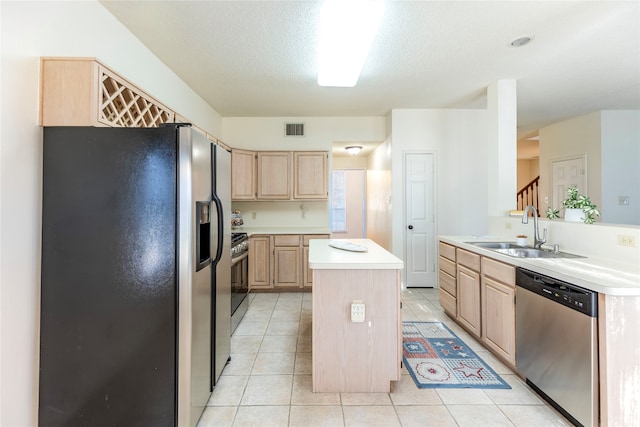 kitchen featuring light brown cabinets, sink, stainless steel appliances, and an island with sink