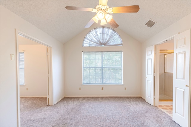 unfurnished room with ceiling fan, light colored carpet, and vaulted ceiling