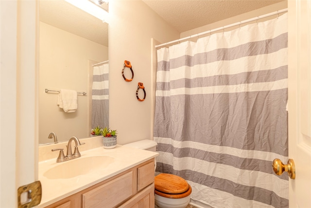 bathroom with a shower with curtain, vanity, toilet, and a textured ceiling