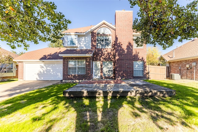 view of front of home with a front yard, central AC, and a garage