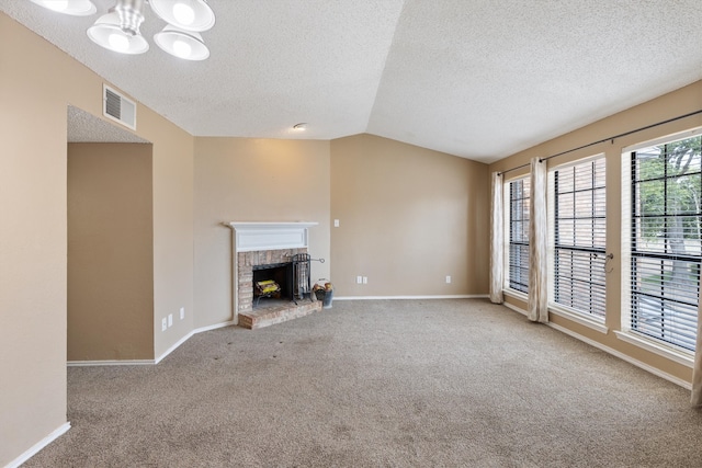 unfurnished living room featuring a textured ceiling, an inviting chandelier, a brick fireplace, vaulted ceiling, and carpet