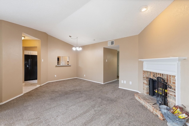 unfurnished living room with a notable chandelier, light carpet, a fireplace, and lofted ceiling