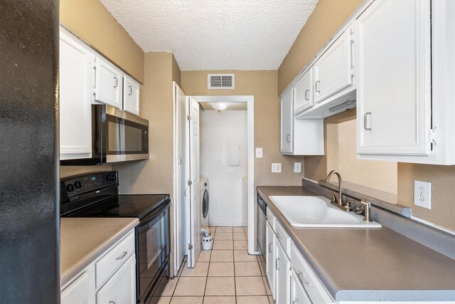 kitchen featuring black appliances, white cabinets, sink, light tile patterned floors, and a textured ceiling