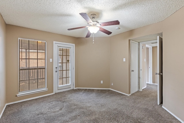 empty room with carpet floors, a textured ceiling, and ceiling fan