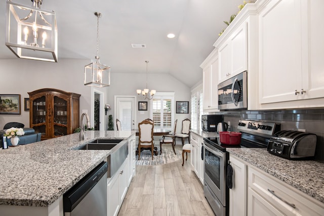 kitchen featuring white cabinetry, stainless steel appliances, decorative backsplash, light stone countertops, and light hardwood / wood-style floors