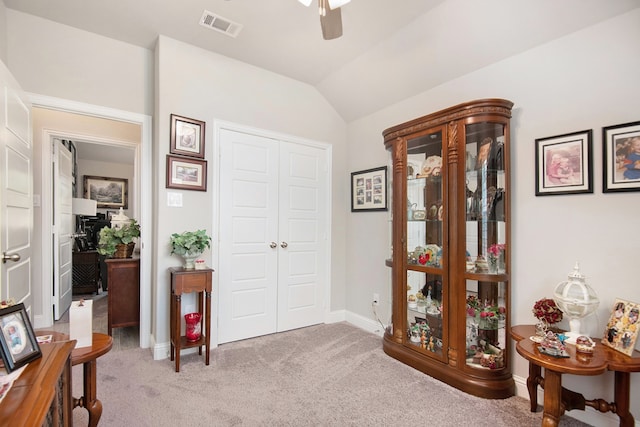 sitting room with lofted ceiling, light colored carpet, and ceiling fan