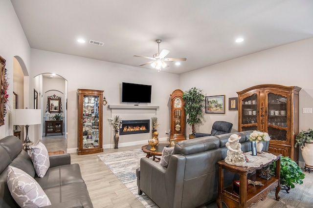 living room with light hardwood / wood-style floors and ceiling fan