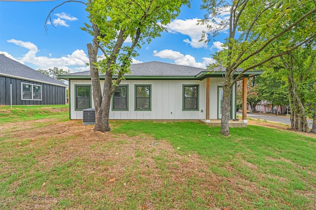 rear view of property with a lawn and central AC unit