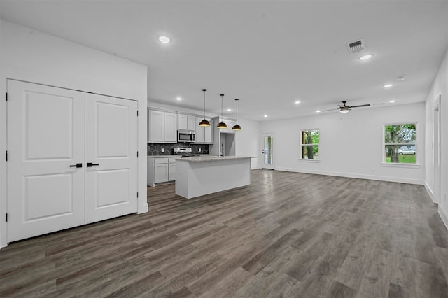 unfurnished living room with ceiling fan and dark hardwood / wood-style floors