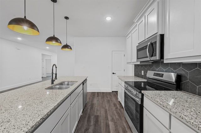 kitchen featuring dark hardwood / wood-style floors, pendant lighting, stainless steel appliances, sink, and white cabinetry