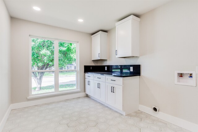 laundry room featuring washer hookup, a healthy amount of sunlight, and cabinets