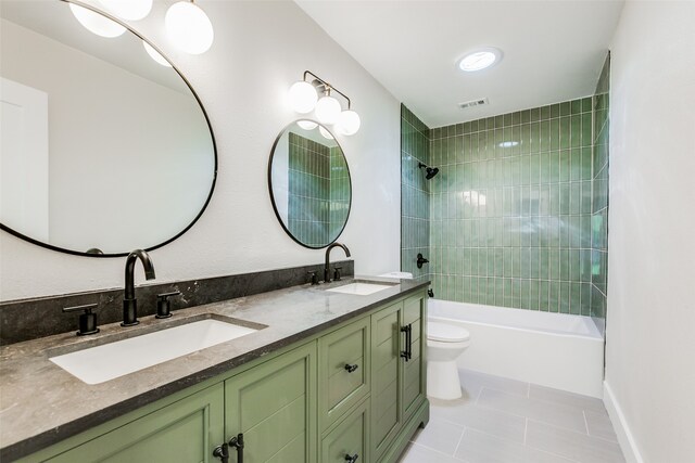 full bathroom featuring tile patterned flooring, vanity, toilet, and tiled shower / bath